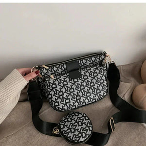Black and white patterned crossbody bag with matching coin pouch on beige fabric