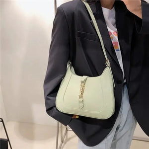 Woman in black blazer with pastel green leather shoulder bag, modern fashion accessory