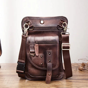 Brown leather crossbody bag with multiple zip pockets and adjustable strap on wooden table