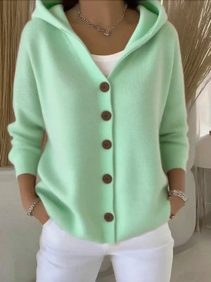 Woman wearing mint green button-up hooded cardigan and white pants, casual cozy style