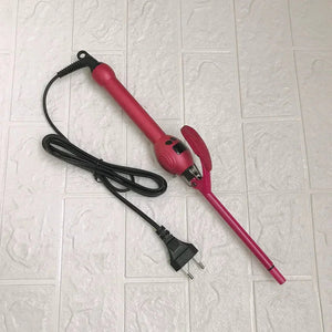 Pink curling iron hair styling tool with clamp and power cord on light tile background