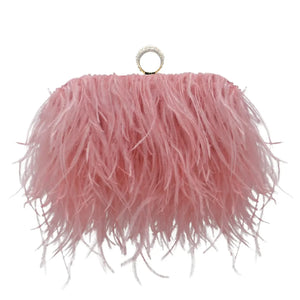 Pink feather clutch purse with gold ring handle on white background