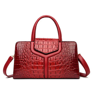 Red crocodile-embossed leather handbag with top handles and detachable shoulder strap