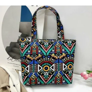 Colorful geometric print tote bag with tribal pattern, displayed on a white surface
