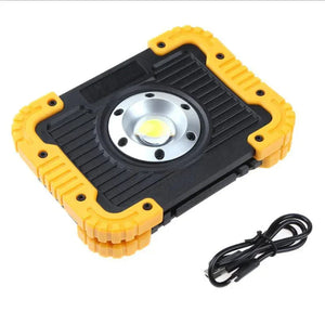 Portable LED work light with rugged black and yellow case and USB charging cable