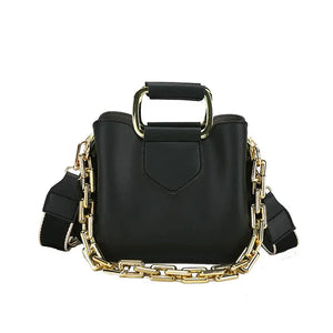 Black handbag with gold chain strap and top metal handle, modern fashion accessory