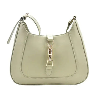 Beige leather shoulder bag with gold buckle detail and adjustable strap on white background