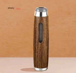 Wood and metal spice grinder with mesh window on neutral background