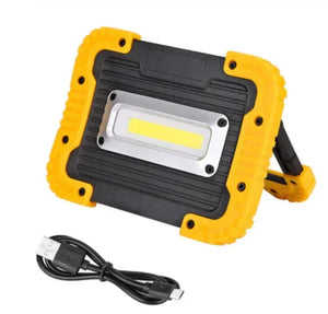 Portable LED work light with yellow and black frame, includes USB charging cable