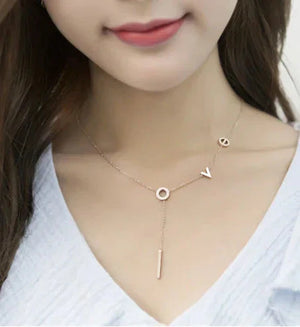 Gold letter pendant necklace on woman, delicate fashion jewelry, close-up on collarbone