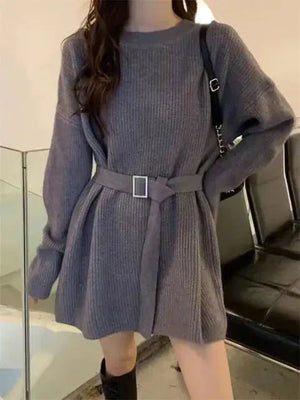 Woman wearing a belted grey knit sweater dress with long sleeves, chic casual fashion