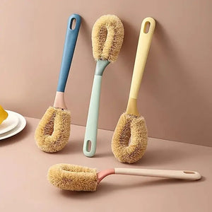 Set of four soft-bristle bottle cleaning brushes with pastel handles on a beige surface