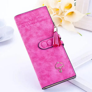 Pink suede women's wallet with tassel and umbrella charm on white background