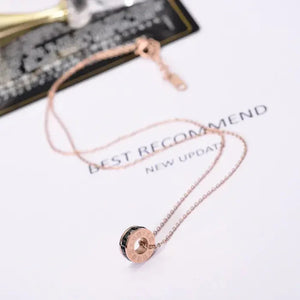 Rose gold chain necklace with circular pendant, stylish jewelry on white background