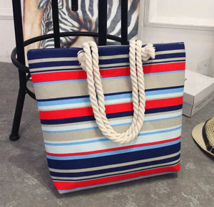 Colorful striped tote bag with thick rope handles, casual fashion accessory on gray floor