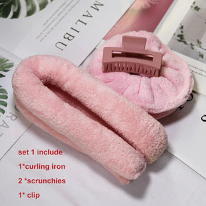 Pink heatless curling set with soft rod, two scrunchies, and a hair clip on a magazine background