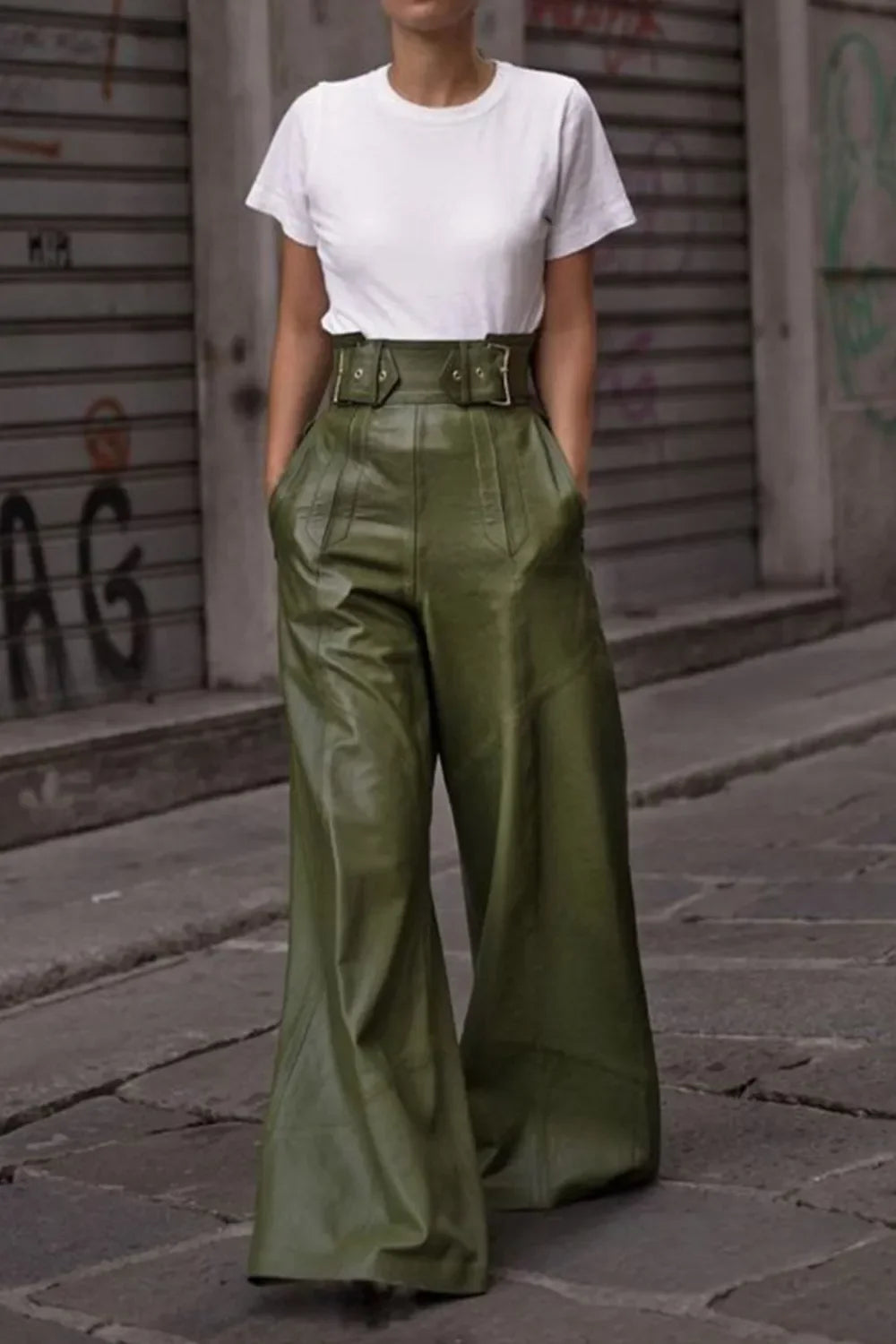 Woman wearing high-waisted green wide-leg pants with belt, white t-shirt, street style