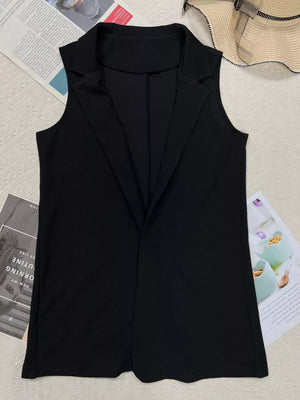 Black sleeveless blazer vest for women, stylish office wear with notched lapel, laid on magazine background