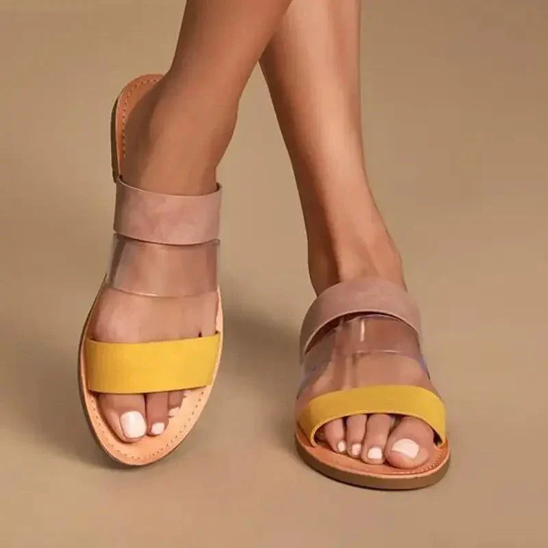 Woman wearing open-toe sandals with yellow and transparent straps on beige background